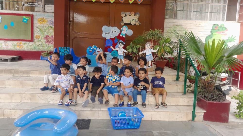 Young Joyland Montessori School children sitting together on the steps outside their classroom