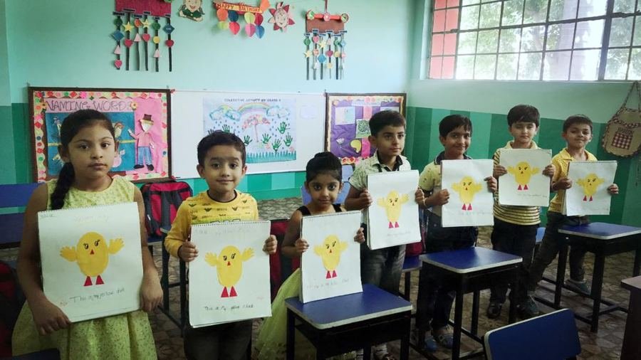Joyland children holding up their own drawings in a classroom