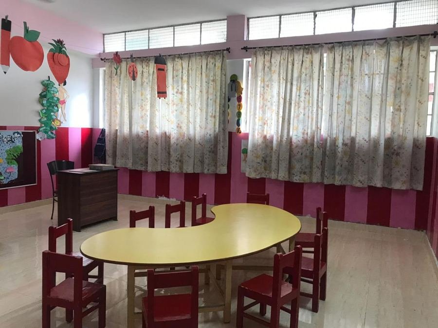 A bright Joyland classroom with low tables, chairs and curtained windows