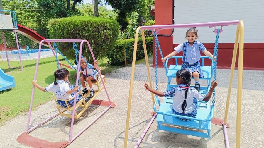 Joyland Montessori School children swinging together in the school garden